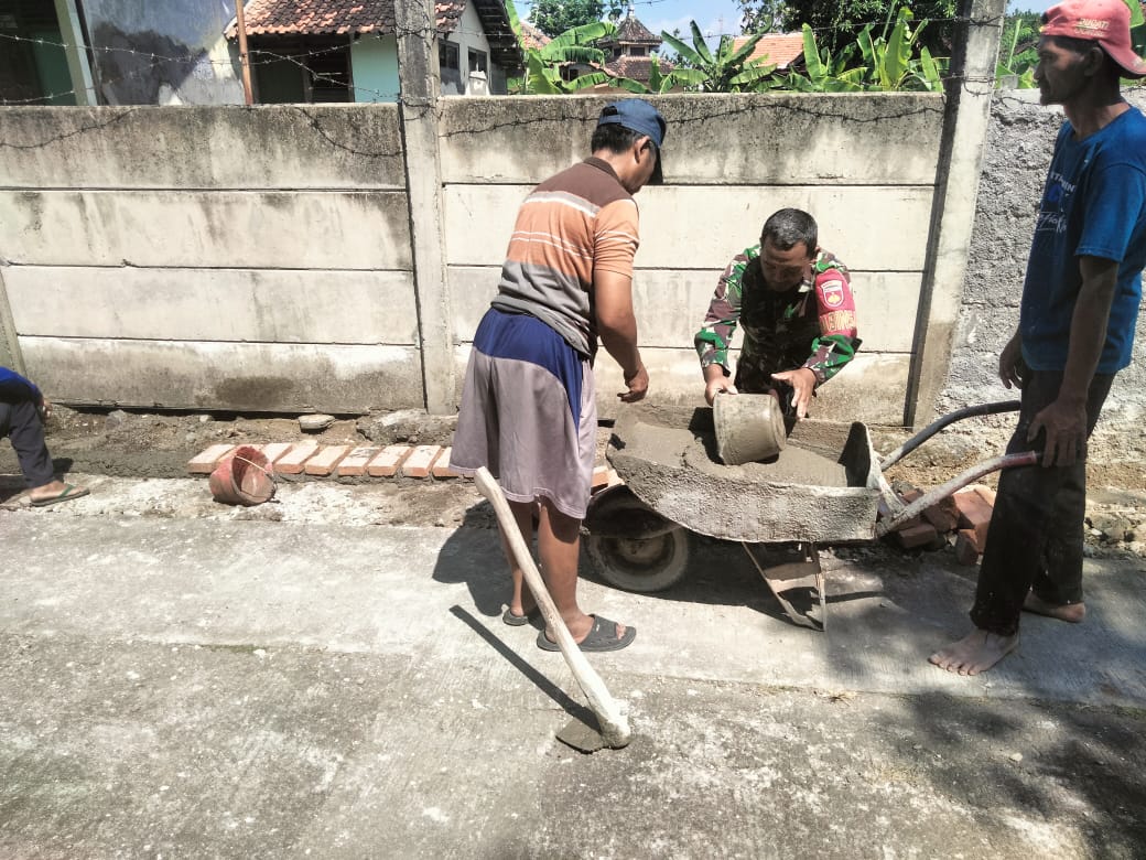 Serma Surasno bersama masyarakat saat bergotong royong melanjutkan pembangunan talud jalan di Dukuh Ngrowo, Desa Pilangsari, Kecamatan Ngrampal, Kabupaten Sragen, Jumat (22/3/2024). (foto: agus kemplu)
